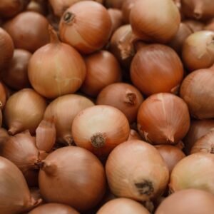 Fresh organic brown onions piled together showcasing natural texture in a close-up shot.